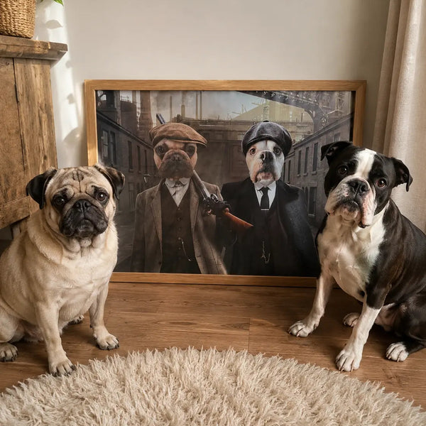 Two dogs, a fawn pug on the left and a black-and-white Boston Terrier on the right, sit on a wooden floor in front of a large framed art print showing two dogs dressed as Victorian gentlemen. A fluffy cream rug is in the foreground, with a plant and wooden shelf visible on the left.